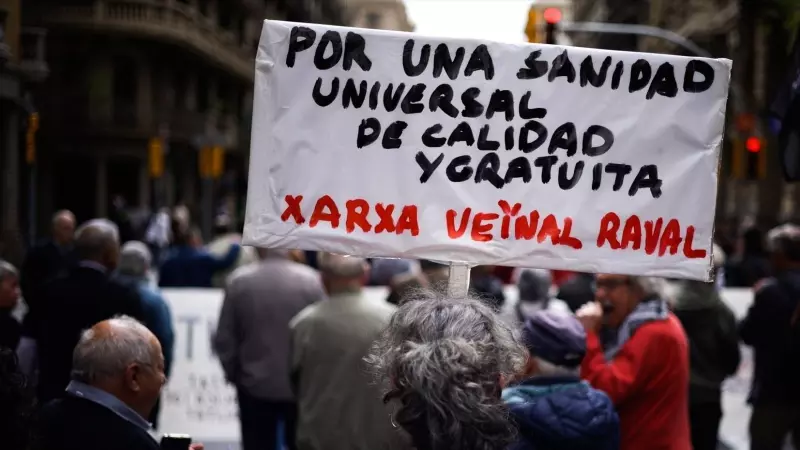 Una mujer sujeta un cartel de protesta durante una manifestación contra la privatización de la sanidad, a 7 de abril de 2024, en Barcelona, Catalunya (España).