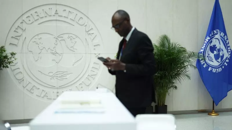 Un hombre lee su teléfono móvil en la sede del FMI en las jornadas previas a la Reunión de Primavera del organismo internacional y del Banco Mundial, en su sede en Washington. AFP/Getty/Alex Wong