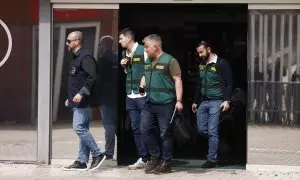 Un agente de la Europol y varios agentes de la Unidad Central Operativa de la Guardia Civil salen de la Real Federación Española de Fútbol, a 20 de marzo de 2024, en Madrid.