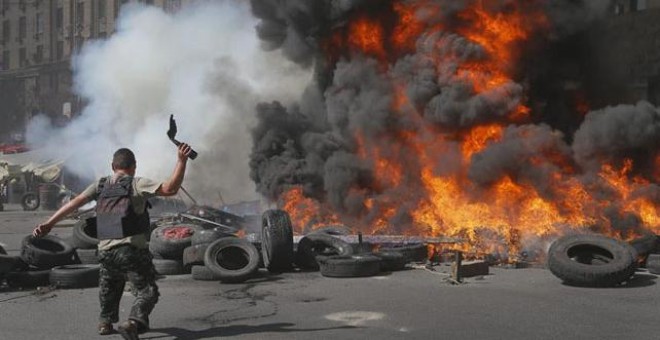 Un activista del Maidán lanza un cóctel molotov durante una protesta contra las autoridades ucranianas que tratan de limpiar la calle.