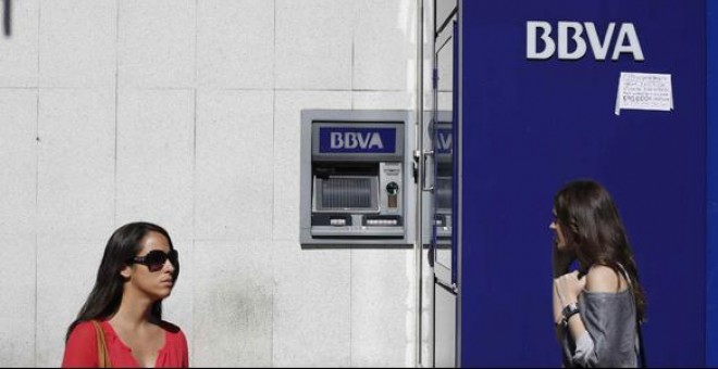 Dos mujeres pasan por delante de una oficina del BBVA en Madrid.