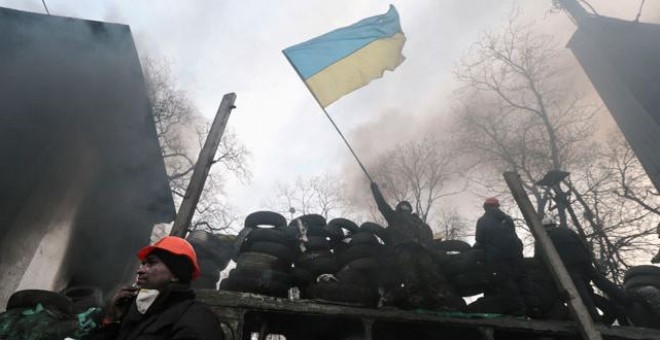 Un manifestante proeuropeo ondea una bandera ucraniana sobre una barricada en la PLaza de la Independencia de Kiev.