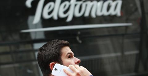 Un hombre habla por su móvil, delante de la sede de Telefónica en la madrileña Gran Vía. REUTERS