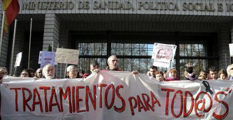 Varias personas participan en una cadena humana, organizada por la Plataforma de Afectados por la Hepatitis C, rodeando el Ministerio de Sanidad para exigir tratamientos para la enfermedad.- EFE/Ballesteros