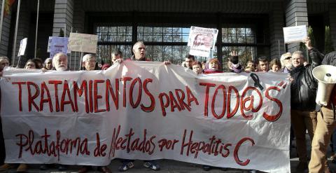 Varias personas participan en una cadena humana, organizada por la Plataforma de Afectados por la Hepatitis C, rodeando el Ministerio de Sanidad para exigir tratamientos para la enfermedad.- EFE/Ballesteros