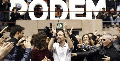 El secretario general de Podemos, Pablo Iglesias y Gema Ubasart,iz, saludan a sus simpatizantes en el mitin celebrado hoy en el pabellón de Vall d'Hebron, en Barcelona.