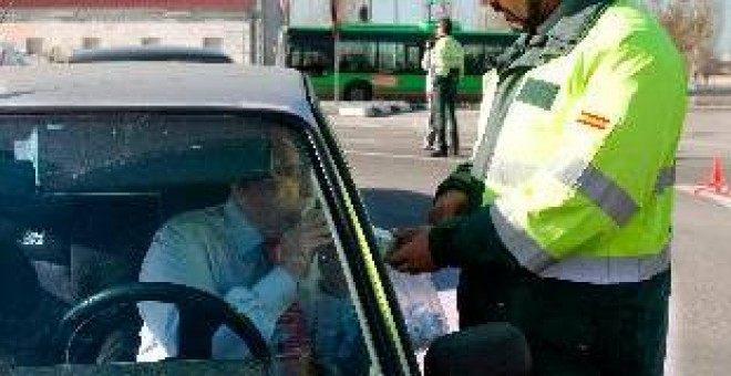 Un guardia civil realiza un control de alcoholemia a un conductor.