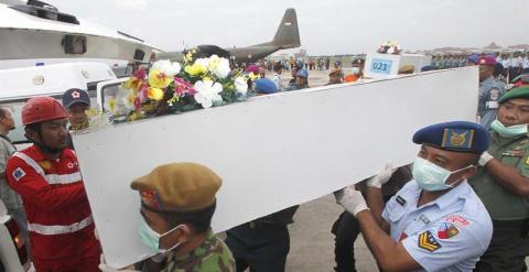 Personal militar de Indonesia cargan con un ataud que contiene el cuerpo de uno de los fallecidos en el accidente de avión. EFE