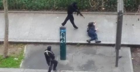 Imagen de un video amateur en el que se ve a uno de los atacantes de la revista 'Charlie Hebdo' disparando contra un policía que yace herido en el suelo. REUTERS