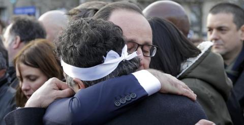 El presidente francés Hollande consuela al columnista de la revista 'Charlie Hebdo', Patrick Pelloux. /REUTERS