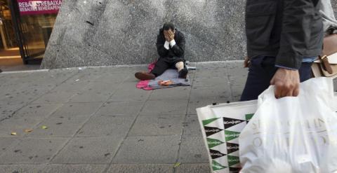 Un sin techo, en la puerta de un centro comercial en temporada de rebajas. REUTERS