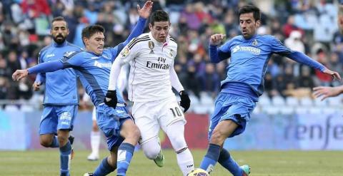 El jugador colombiano del Real Madrid, James Rodríguez, intenta pasar entre los jugadores del Getafe, el uruguayo Emiliano Daniel Velazquez,iz., y Juan Antonio Rodriguez,d., durante el partido de la decimonevena jornada de la Liga BBVA. /EFE