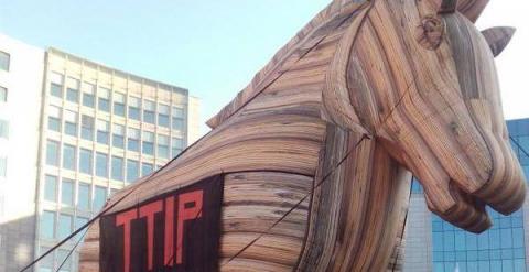 El caballo de Troya colocado frente a la sede de la Comisión Europea en Bruselas, en la protesta contra el Tratado de Libre Comercio, con algunos activistas de la organización Friends of the Earth.