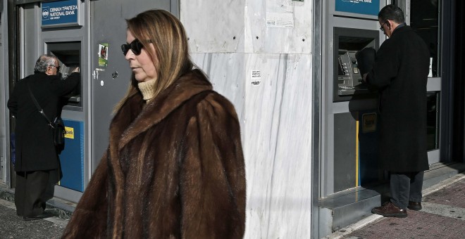 Dos clientes operan en los cajeros automáticos del Banco Nacional de Grecia. REUTERS/Alkis Konstantinidis