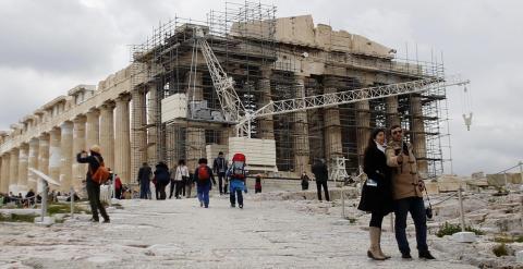 Unos turistas se hacen un selfie con el Partenon al fondo en la Acrópolis de Atenas. REUTERS/Kostas Tsironis