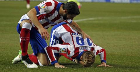 Torres besa el césped del Calderón tras marcar un gol en su vuelta al Atlético. /REUTERS