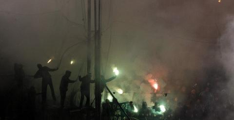 Aficionados del Panathinaikos lanzan bengalas durante el derbi. REUTERS/Kostas Tsironis