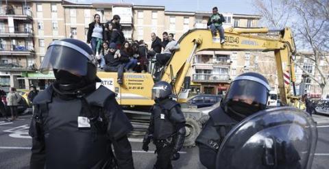 Agentes de Policía Municipal ante las personas subidas en una excavadora que trataban de evitar el desalojo de la vivienda en el número 29 de la calle Ofelia Nieto./ EFE-Javier Lizón