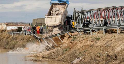 Efectivos de la Unidad Militar de Emergencias (UME) trabajan en la reconstrucción de un puente caído entre las regiones de Boquiñeni y Luceni tras la crecida del río Ebro. Mas de un millar de vecinos de Pradilla y Boquiñeni fueron desalojados ayer y han p