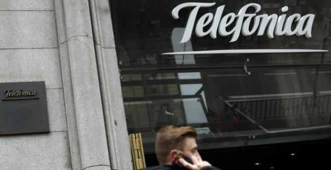 Un hombre habla con su móvil delante de la sede de Telefónica en la Gran Vía madrileña. REUTERS