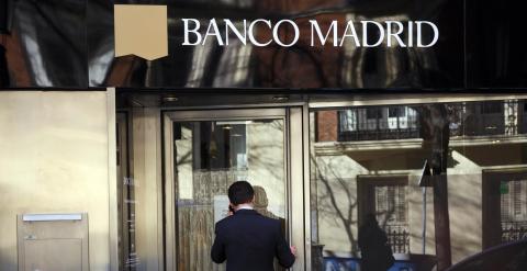 Un hombre delante de una oficina de Banco Madrid. REUTERS
