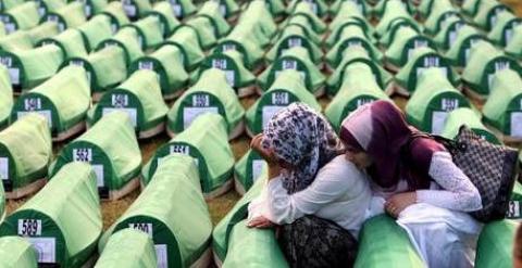 Dos mujeres se lamentan junto a los féretros en Srebrenica./ EFE