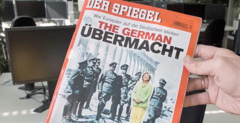 Un hombre sostiene un ejemplar de la revista 'Der Spiegel' con un montaje en su portada de la canciller Angela Merkel rodeada de jerarcas nazis. EFE