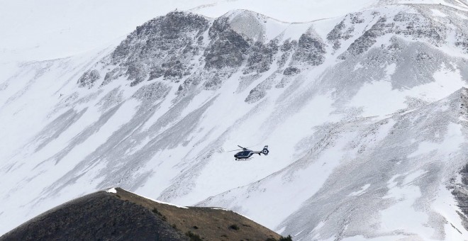 Un helicóptero de rescate de la Gendarmería francesa vuela sobre los Alpes franceses durante las operaciones de búsqueda de los restos del avión Airbus A320 estrellado este martes. El aparato de Germanwings cayó en la región de los Alpes Haute Provence y