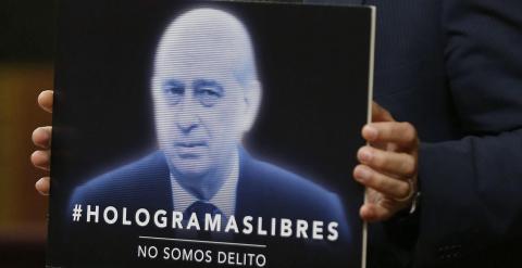 El portavoz de la Izquierda Plural, Ricardo Sixto, sostiene una pancarta con la Le Mordaza durante su intervención en el pleno del Congreso de los Diputados. EFE/Paco Campos