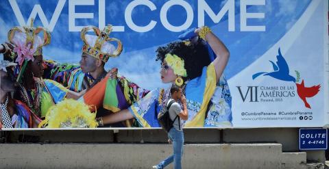 Un hombre pasa junto a un cartel de la Cumbre de las Américas que se celebrará en Ciudad de Panamás el 10 y 11 de abril. - AFP
