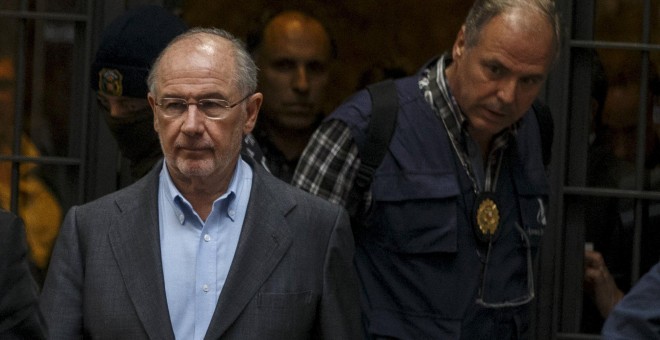 Rodrigo Rato, sale con agentes de la Policía, tras el registro de su domicilio. REUTERS/Sergio Perez