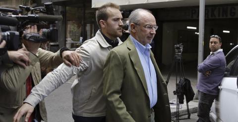 El exvicepresidente del Gobierno, Rodrigo Rato, acompañado de un guardaespaldas, sale de su domicilio donde numerosos medios de comunicación esperan noticias. EFE/Sergio Barrenechea