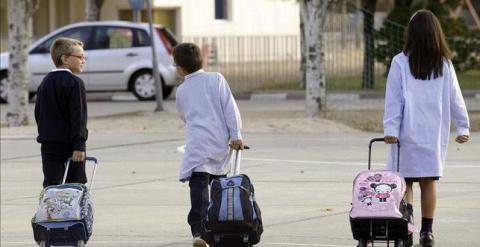 Dos niños y una niña, camino del colegio./ EFE