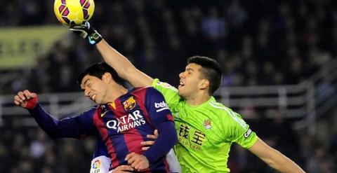 Gerónimo Rulli despeja un balón ante Luis Suárez en el partido de ida entre el Barcelona y la Real Sociedad en Anoeta.