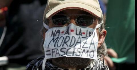 Una persona enmascarada protestando contra la ley mordaza, en la concentración en la madrileña Puerta del Sol para celebrar el cuarto aniversario del 15M.. REUTERS/Andrea Comas