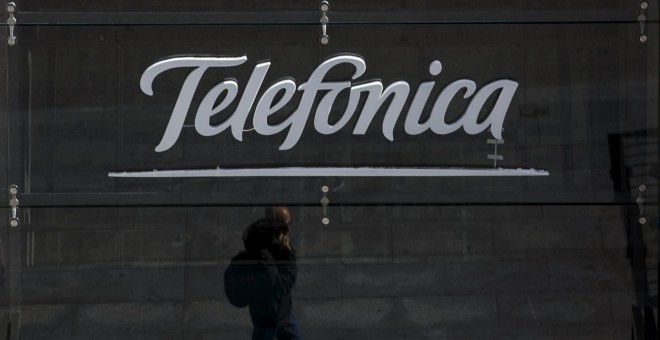 El reflejo de un viandante en el cristal del escaparate de una tienda de Telefónica en la sede de la Gran Vía madrileña. REUTERS/Sergio Perez