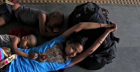 Una mujer descasnsa con sus hijos en una estación de tren en un caluroso día de la ola de calor que azota la India, en Allahabad. REUTERS/Jitendra Prakash
