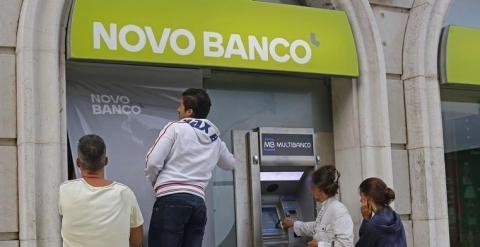 Dos operarios colocan el cartel de Novo Banco en una oficina de la entidad, en Lisboa. REUTERS