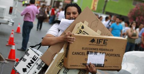 Un miembro del Instituto Nacional Electoral (INE) traslada material electoral en Ciudad Juárez. / JOSÉ LUIS GONZÁLEZ (EFE)