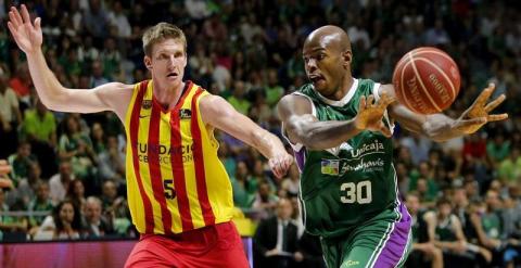 El ala-pívot estadounidense de Unicaja Caleb Green (d) pasa el balón ante su compatriota Justin Doellman, del FC Barcelona. /EFE