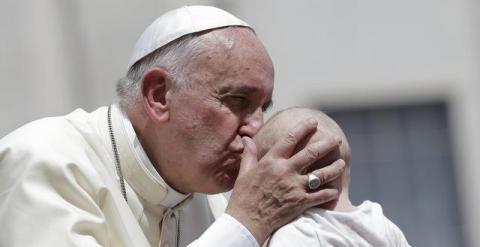 El Papa Francisco besa a un bebé antes de abandonar la Plaza de San Pedro en el Vaticano tras finalizar su audiencia general del miércoles./ REUTERS