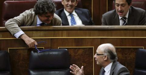 El ministro de Hacienda, Cristóbal Montoro, conversa con Jorge Moragas, en su escaño de diputado. EFE/Emilio Naranjo