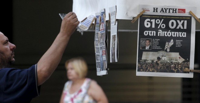 A man looks at newspapers showing the results of yesterday's referendum in central Athens, Greece, July 6, 2015. Greeks overwhelmingly rejected conditions of a rescue package from creditors on Sunday, throwing the future of the country's euro zone members