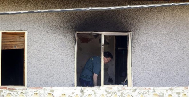Agentes de la Guardia Civil investigan en una de las habitaciones de la residencia privada de Santa Fe, en la localidad de Cuarte de Huerva, cerca de Zaragoza, donde anoche un incendio causó la muerte a ocho ancianos y heridas a otros doce./ EFE