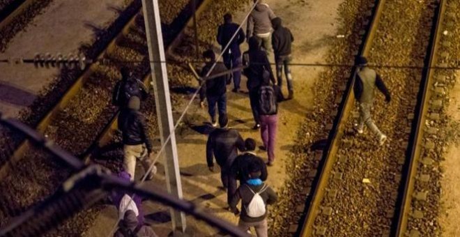 Varios inmigrantes intentan cruzar por las vías del Eurtúnel./ AFP