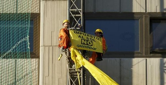 Activistas de Greenpeace despliegan una pancarta contra el 'impuesto al sol' en el Ministerio de Industria. -E.P