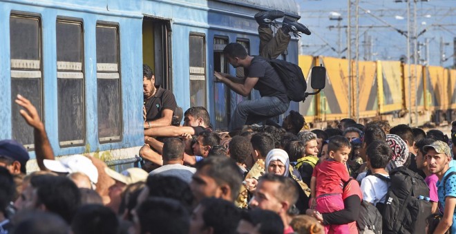 Cientos de personas se agolpan para ocupar una de las plazas de los vagones del tren que parte de la localidad de Gevgelija, Macedonia, junto a la frontera con Serbia. EFE/Georgi Licovski
