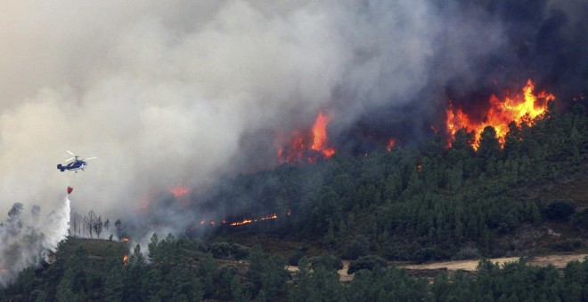 Un helicóptero descarga agua sobre el incendio forestal declarado en la Sierra de Gata, en el límite de Cáceres con la provincia de Salamanca. EFE/Carlos García