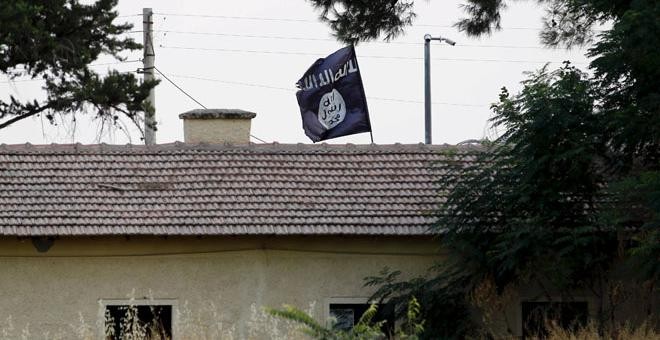 Una bandera del Estado Islámico sobre la oficina de aduanas en la frontera de Jarablus en Siria. REUTERS/Murad Sezer