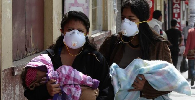 Residentes usan mascarillas tras una erupción de ceniza del volcán Cotopaxi.- EFE